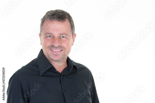 Portrait of cheerful middle aged man in casual smiling over white background and looking camera © OceanProd