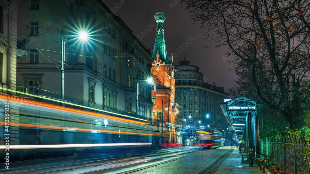 Tramwaj w ruchu na krakowskiej ulicy Basztowej. Kolorowe smugi po ruchu tramwaju - obrazy, fototapety, plakaty 