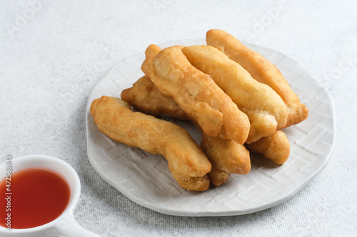 Cakwe or Cakue or Youtiao is traditional Chinese snack, long golden-brown deep-fried strip of dough and very popular in China and Asia. Selective focus image, copy space.
 photo