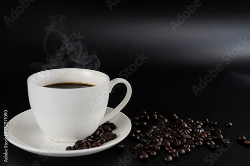 Cafes and restaurants. A mug of invigorating, black coffee and coffee beans on dark gray background.