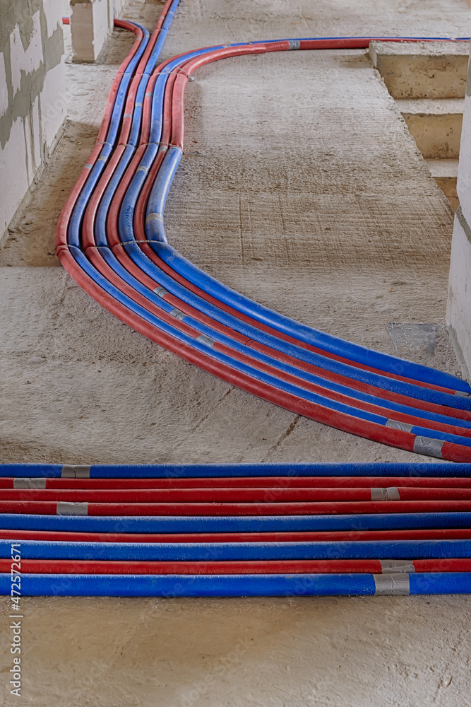 Red and blue pipes of the water supply and heating system in a country