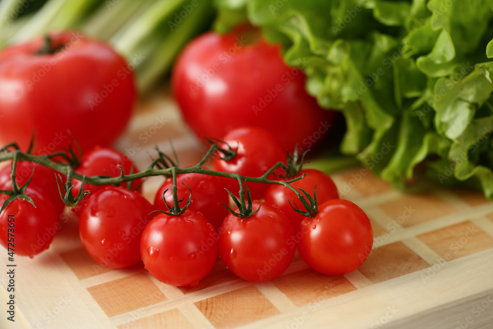 On the table are red tomatoes and green salad On the table are red tomatoes and green salad