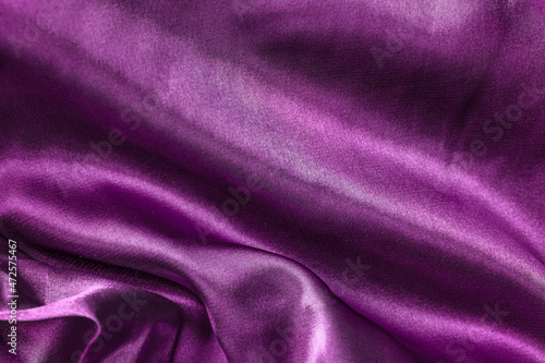 Elegant smooth violet silk or satin folds closeup. Cloth texture background. Abstract wallpaper. Trendy velvet bright violet backdrop for web design. Luxury twisted fabric backplate. Banner