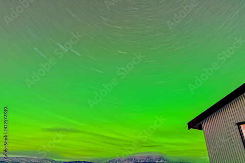 Aurora borealis lights, river and house edge long exposure
