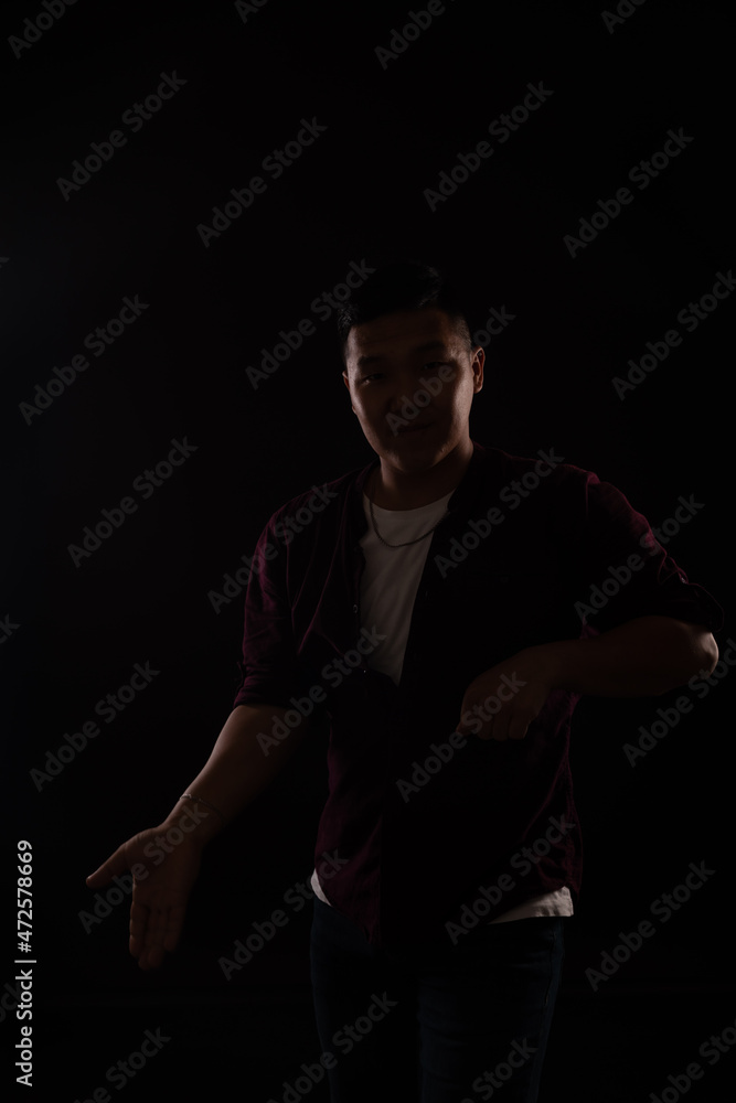 Asian man dancing to music in the dark at a disco