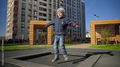 Wallpaper Mural Cheerful little boy smiling while jumping on trampoline at public park. Concept of child development, sports and education. Torontodigital.ca