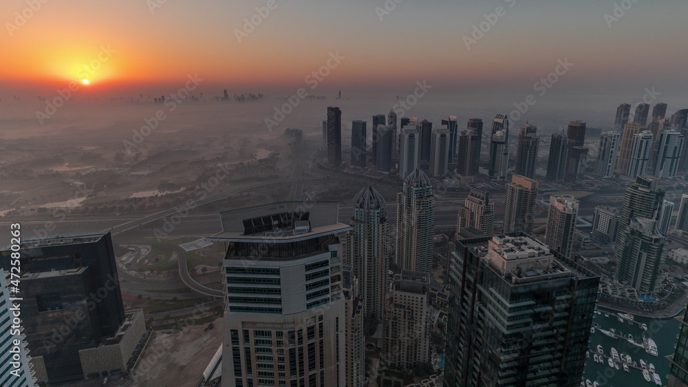 Panorama of Dubai Marina with JLT skyscrapers and golf course during sunrise timelapse, Dubai, United Arab Emirates.