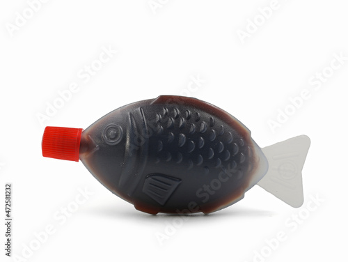 Schilderij op canvas Fish shaped plastic takeaway container serving of soy sauce isolated on a white