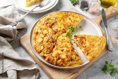 Frittata or potato pie in a ceramic plate on a light culinary background. Traditional Italian delicious homemade egg dish on the kitchen table