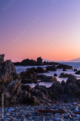 ニュージーランド 首都ウェリントンの夕方のレッド・ロックス・リザーブの岩とクック海峡と夕焼け空