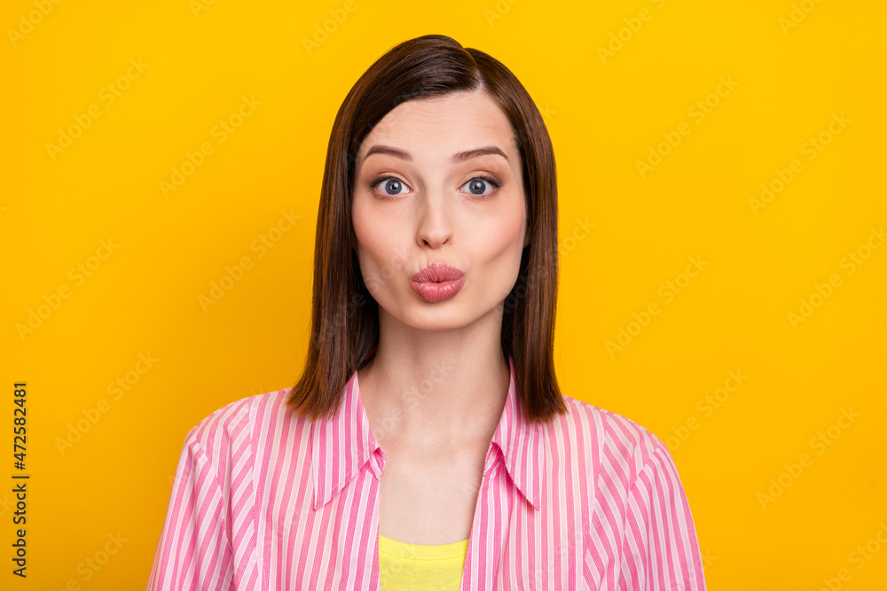 Portrait of pretty positive person kiss lips look camera have good mood isolated on yellow color background Portrait of pretty positive person kiss lips look camera have good mood isolated on yellow color background