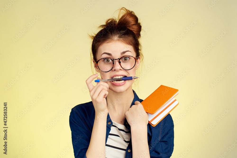 woman student with glasses notepad with pen yellow background woman student with glasses notepad with pen yellow background