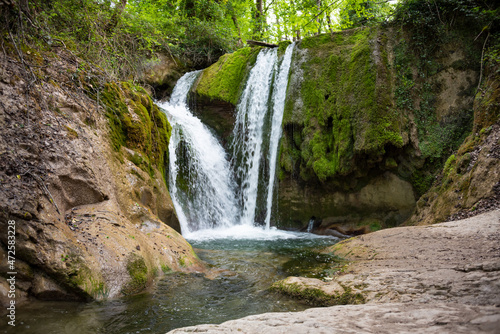 Beautiful waterfall in green forest among trees