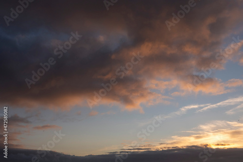 Dark dramatic sunset cloudy sky. Nature background. Warm and cool tone.