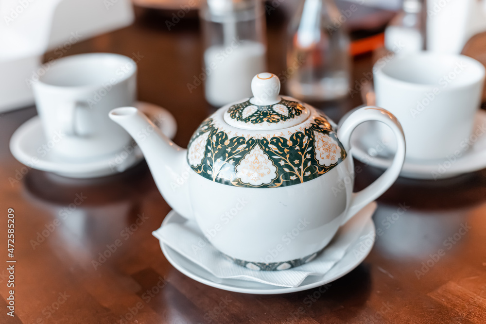 Teapot and two cups on a table in cafe Teapot and two cups on a table in cafe