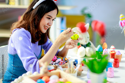 Close up of woman painting Easter eggs by paint..