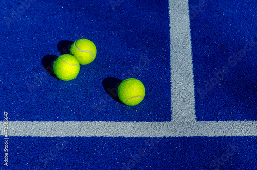 Three balls next to the lines in a paddle tennis court. © Vic