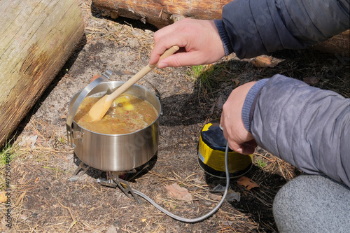 Camping food making. Tourist foods in outdoor activities. Soup in bowler in the forest for trevelers. photo