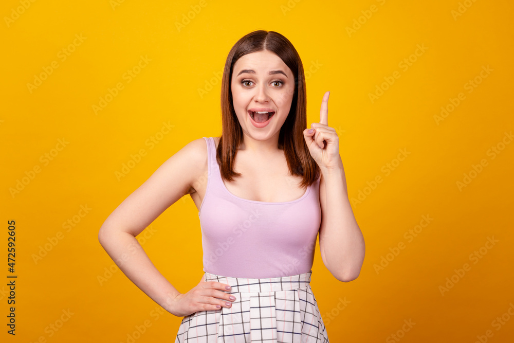 Photo of young lovely woman have idea indicate finger choose decision solution isolated over yellow color background Photo of young lovely woman have idea indicate finger choose decision solution isolated over yellow color background