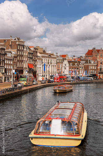 Photography Amsterdam city with tourist boats on canal during springtime in Netherlands