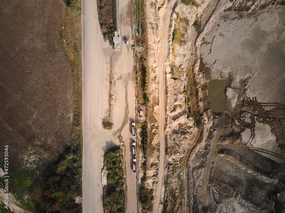 Aerial view of Slope operating granite quarry with mining equipment on ledges