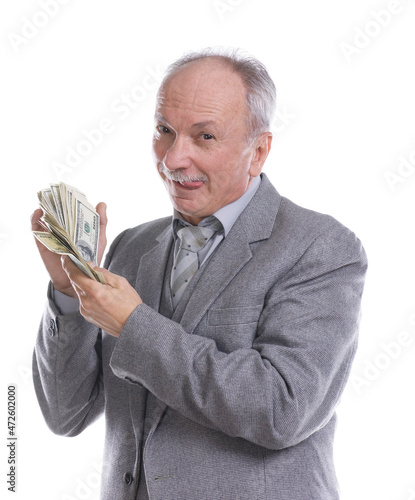 Smiling senior businessman holds pack of dollars