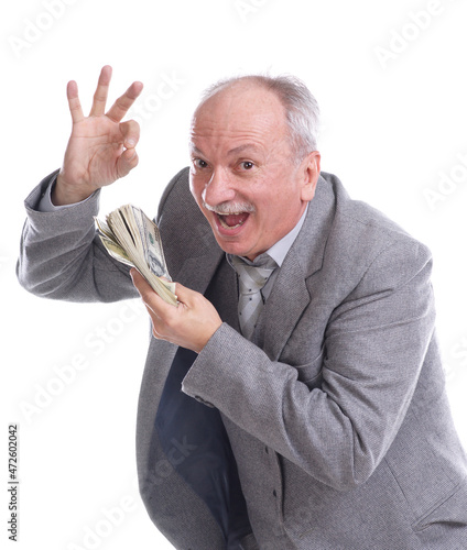 Smiling senior businessman holds pack of dollars