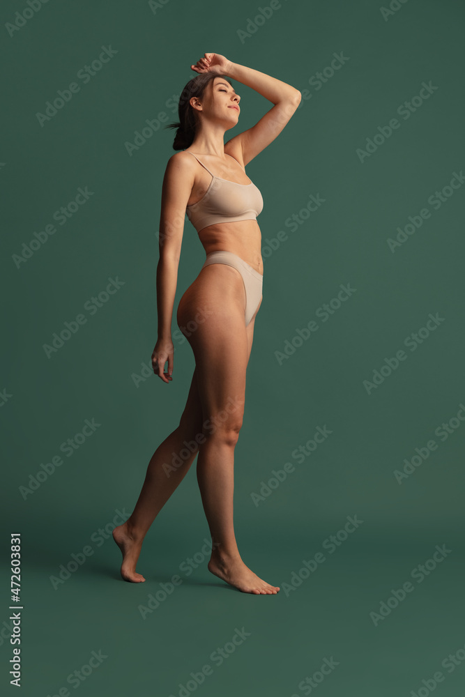 Foto de Portrait of young beautiful slim woman in nude color