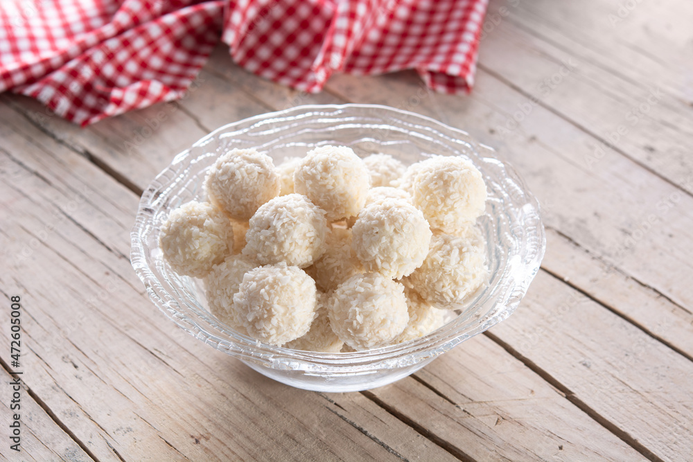 Homemade coconut balls in crystal bowl on wooden table