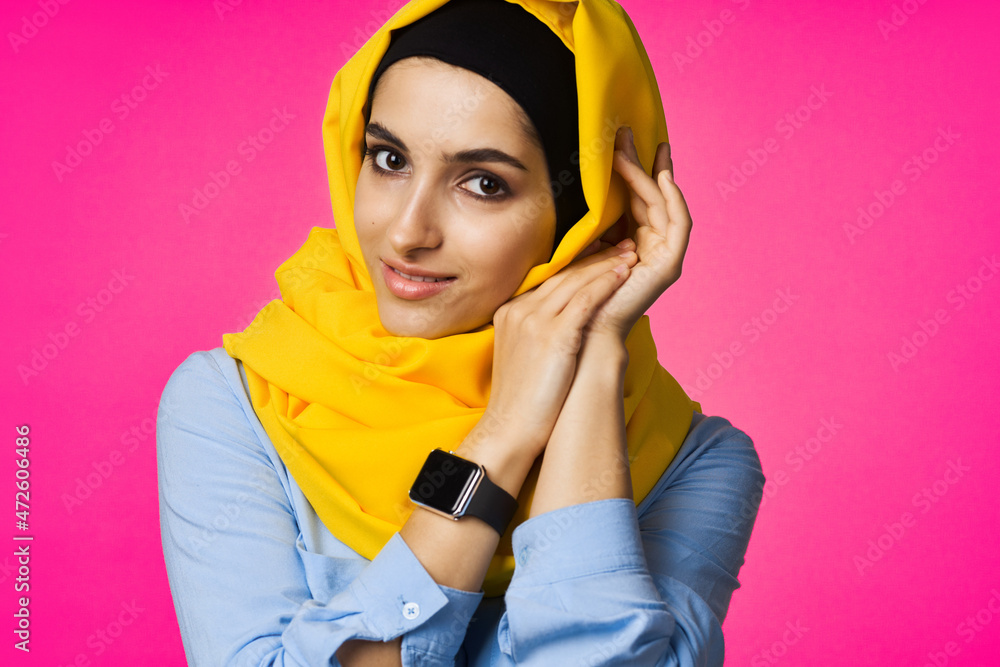 muslim woman with smart watch technology posing pink background