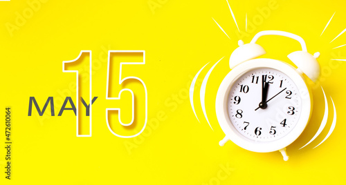 Wallpaper Mural May 15th. Day 15 of month, Calendar date. White alarm clock with calendar day on yellow background. Minimalistic concept of time, deadline. Spring month, day of the year concept. Torontodigital.ca