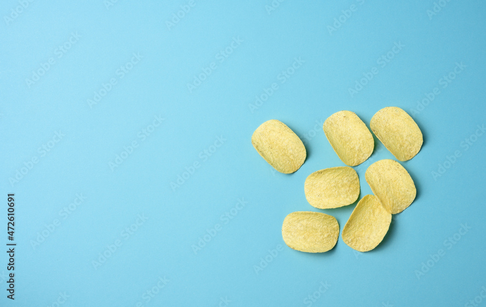 round potato chips on a blue background, top view round potato chips on a blue background, top view
