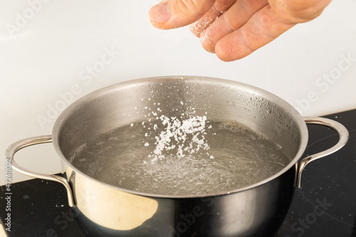 pour salt into a metal pot of boiling water with your hand