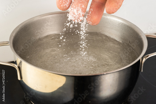 pour salt into a metal pot of boiling water with your hand