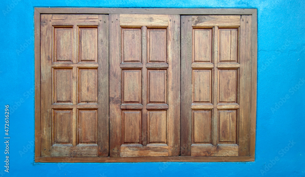 Wooden window on blue wall