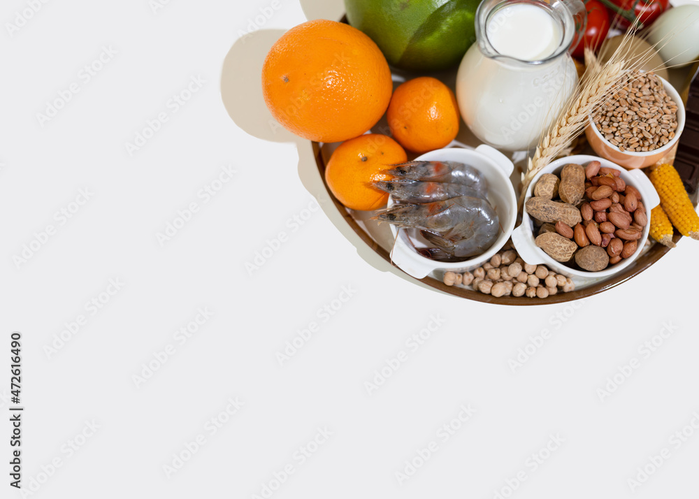 Elimination diet concept. Food allergens on plate - fish, seafood, dairy, peanuts, tree nuts, eggs, chocolate, wheat, soy, citrus fruits. Elimination diet concept. Food allergens on plate - fish, seafood, dairy, peanuts, tree nuts, eggs, chocolate, wheat, soy, citrus fruits.