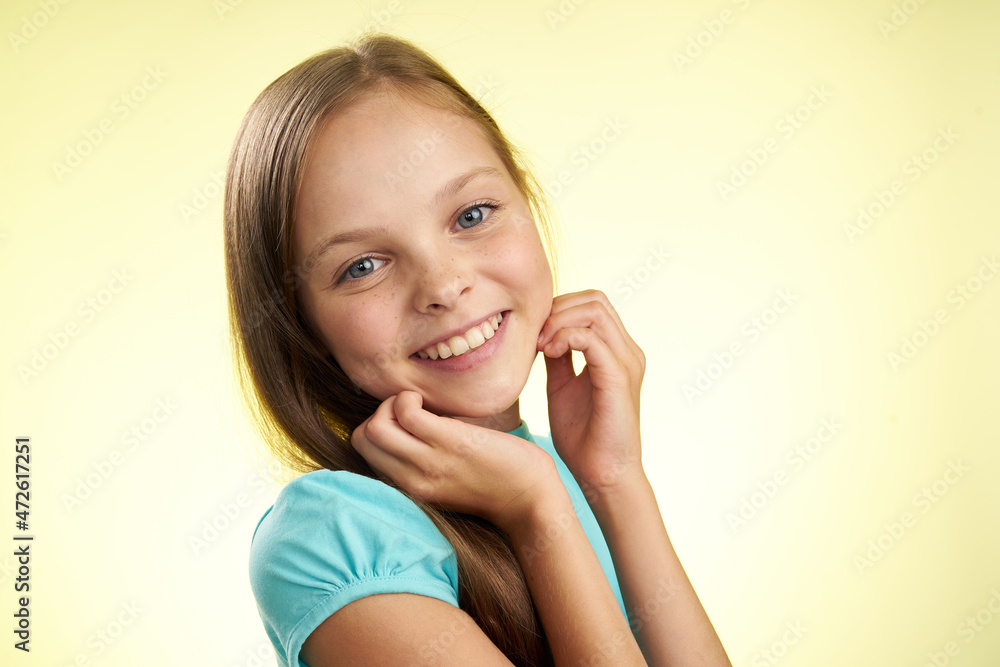 Fototapeta premium cheerful little girl with long hair close-up studio posing