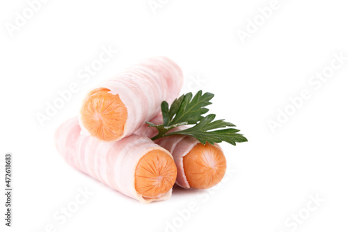 Uncooked German sausages wrapped in bacon with parsley isolated over white
