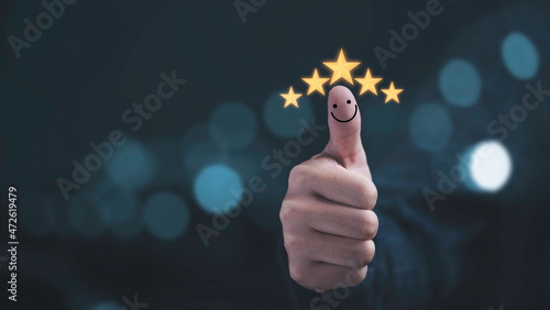 Thumb rise up with yellow five stars and smile face for customer satisfaction and evaluation after use product and service concept.