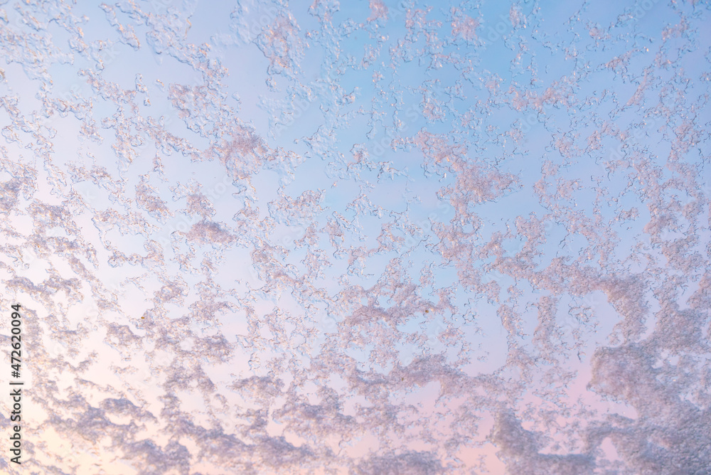 Fototapeta premium snow crystals at the window glass, sunset scenery