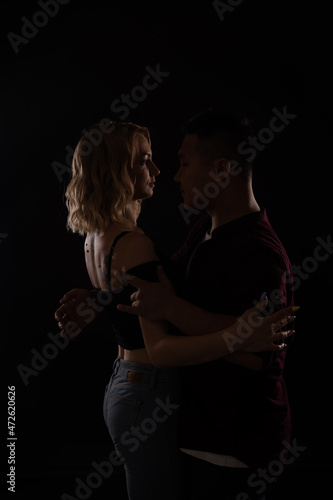 a man and a woman dance to music in the darkness of a disco