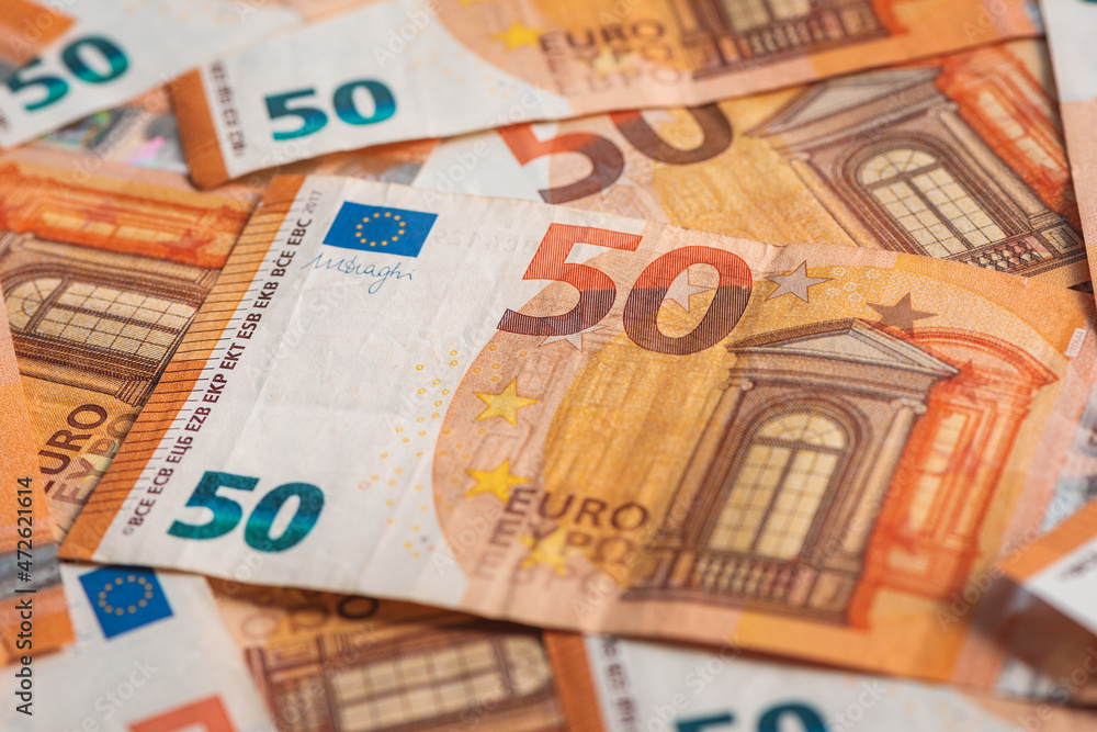 Fifty euros paper banknotes scattered on the table, top view as financial and business background Fifty euros paper banknotes scattered on the table, top view as financial and business background