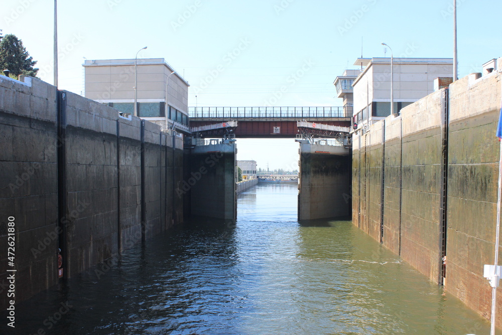 Obraz premium The Volga River. The lock near the reservoir has concrete walls and massive metal gates.