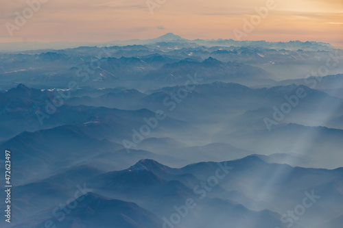 View from the plane to the North Caucasus, in the distance Elbrus. High mountains in the morning haze © Northern life