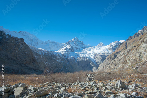 Scenic autumn mountain gorge landscape with snow peaks, Tana glacier, Digor Gorge, Northern Ossetia, Caucasus, Russia