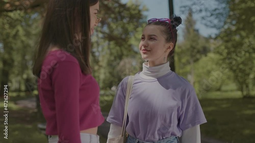 Girls in the park communicate in the park. Two girls spend leisure time walking in the fresh air.