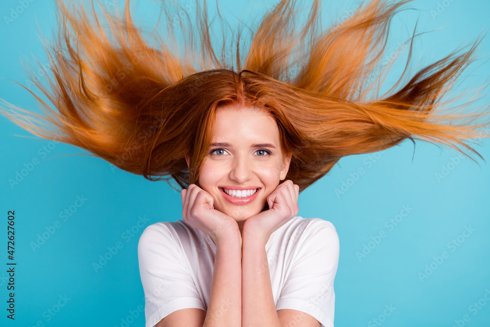 Fototapeta premium Photo of young girl happy positive smile hands touch chin wind blow ginger hair enjoy new conditioner isolated over blue color background