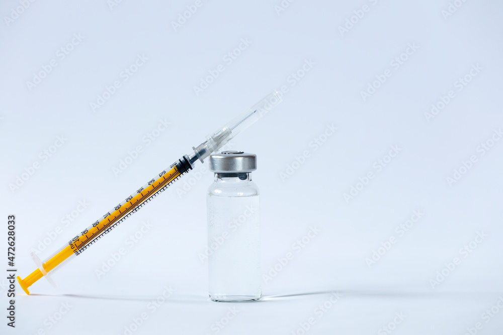 The vaccines vials glass bottle and disposable syringe on white The vaccines vials glass bottle and disposable syringe on white