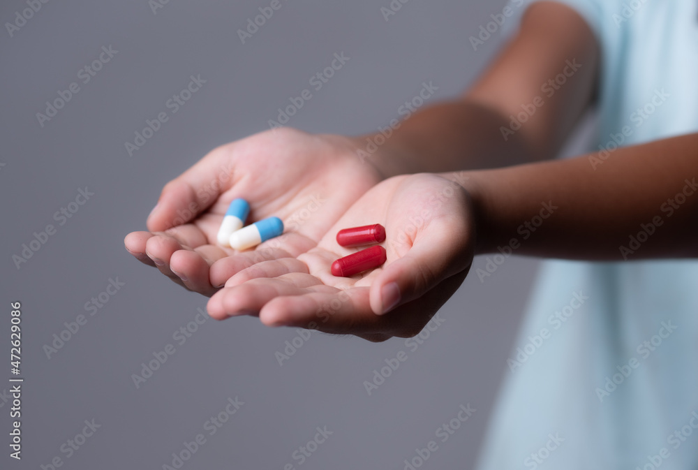 Female offering you red and blue pills,Concept of ugly truth vs beautiful lie, reality vs fiction. Female offering you red and blue pills,Concept of ugly truth vs beautiful lie, reality vs fiction.
