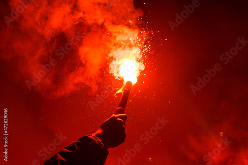 Burning red flare, flame, football hooligan photo
